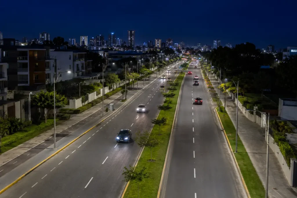 Avenida urbana con iluminación LED uniforme diseñada para carreteras y vías públicas.
